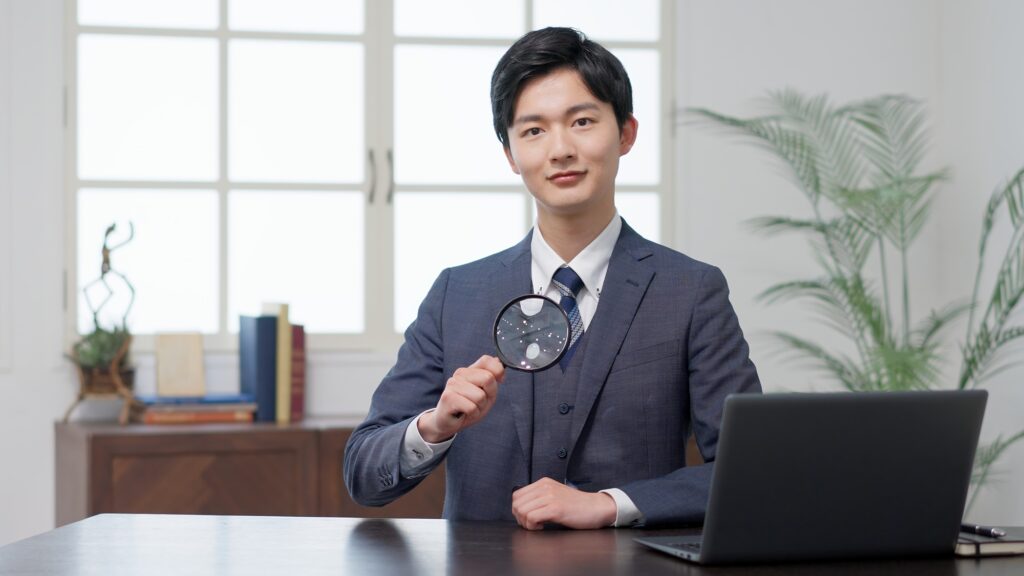 Businessman raising a magnifying glass to his chest