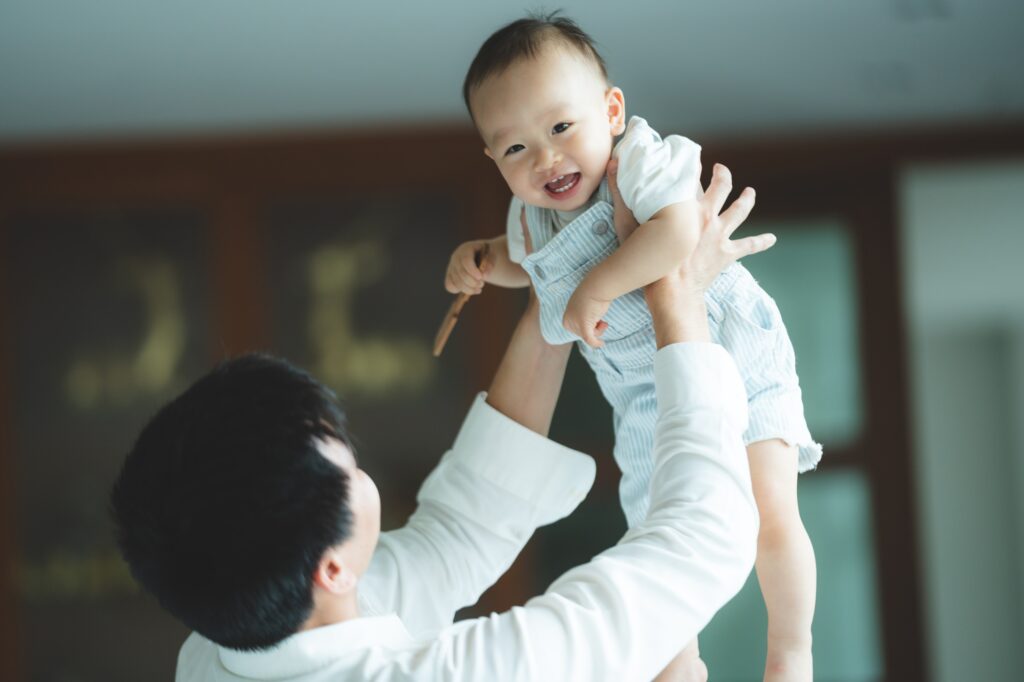 Father's Day concept, young Asian father holding a baby child with family person at home